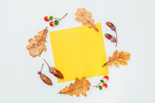 Foto geel leeg frame en eikenbladeren en eikels op witte achtergrond. herfstmodel. minimale herfstsamenstelling, herfstconcept. platliggend, bovenaanzicht en kopieerruimte.
