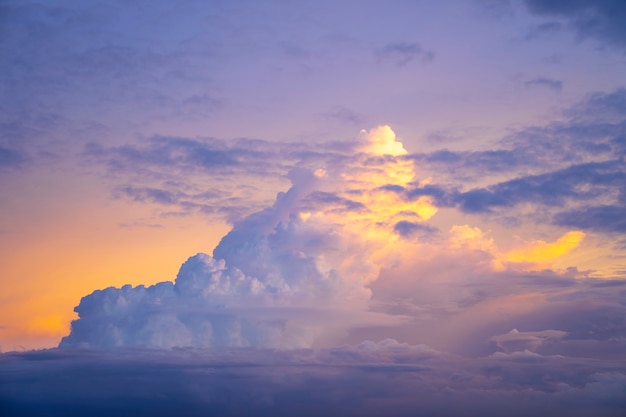 Geel licht van zonsondergang achter grote wolk op schemerhemel, mooie dramatische bewolkte hemel zoals hemel