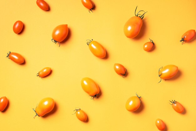 Geel tomatenpatroon op lichte achtergrond Plat lag bovenaanzicht Zomer minimaal concept Veganistisch en vegetarisch dieet