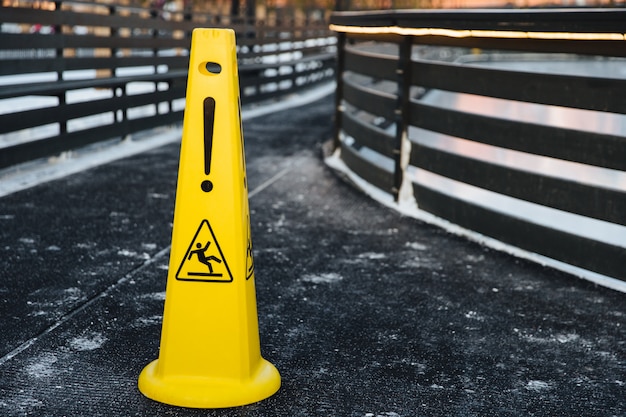 geel waarschuwingsbord staat op grijs asfalt bedekt met sneeuw