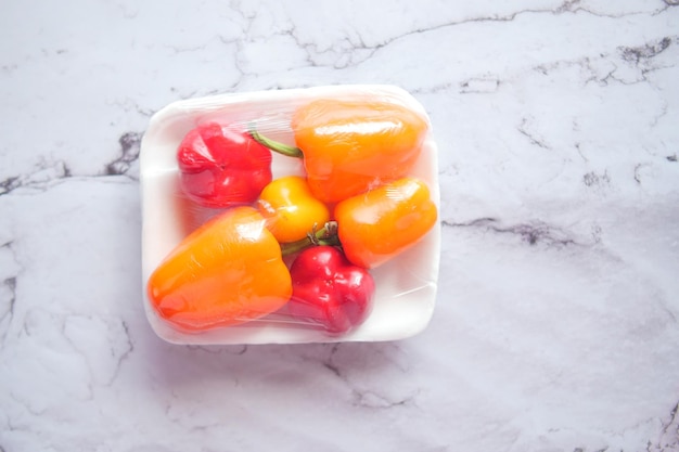 Geeloranje en rode paprika op witte achtergrond