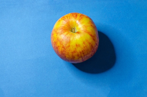 Geelrode appel op een blauwe achtergrond