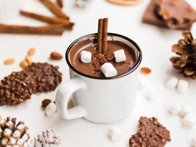 Foto geëmailleerde mok warme chocolademelk met kaneel en marshmallows