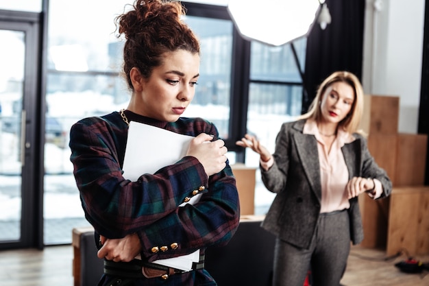 Geen baan krijgen. Curly donkerharige stagiaire voelt zich extreem verdrietig en emotioneel nadat ze geen baan heeft gekregen