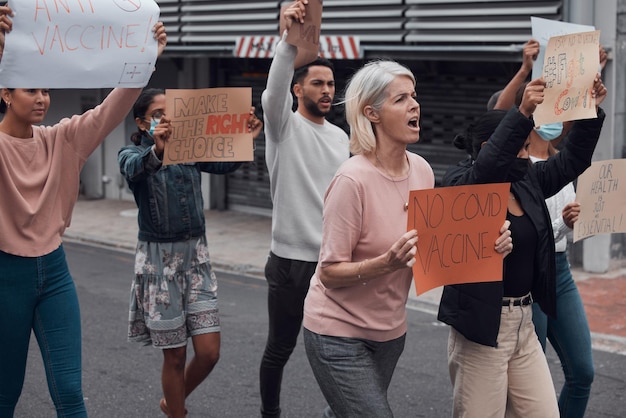 Foto geen covid-vaccin bijgesneden opname van een groep demonstranten die borden omhoog houden die protesteren tegen het covid 19-vaccin