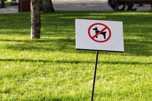Geen hond toegestaan teken in het park met groen gras op de achtergrond