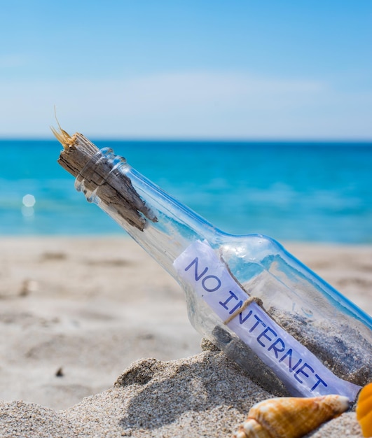 Geen internet geschreven in een fles op een leeg strand