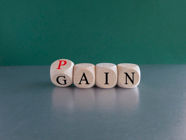 Foto geen pijn geen winstsymbool draaide een houten kubus om en veranderde het rode woord pijn in gain mindset