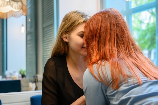 Geen traditioneel stel Twee vrouwen zoenen teder in een café Lesbische relatie LHBT-gemeenschap