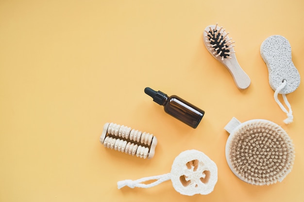 Geen verspilling van badkameraccessoires, natuurlijke borstel, houten kam, olie, make-up remover in een glazen container. levensstijl concept, plat leggen.