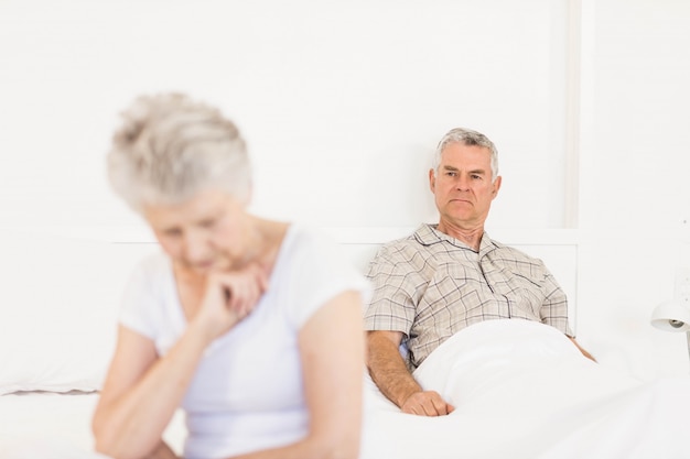 Geërgerd echtpaar negeren elkaar in de slaapkamer