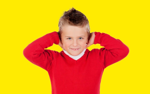 Geërgerd kind vanwege een hard geluid geïsoleerd op een gele achtergrond