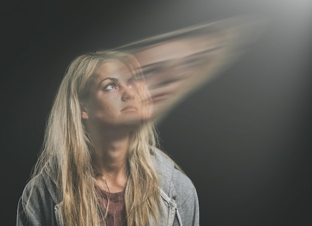 Foto geestelijke gezondheidsangst of bipolaire vrouw denkend in dubbele belichting in donkere studio voor psychologie of trauma schizofrenie of depressief gefrustreerd meisje met depressieangst en paranoïde mockup