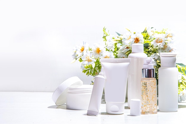 Gefokt en wild geoogst schoonheid Cosmetische huidverzorgingsproducten op witte achtergrond met in het wild gekweekte bloemen Set witte potten buizen druppelaars flessen Spa dagelijkse biologische natuurlijke huidverzorging routine