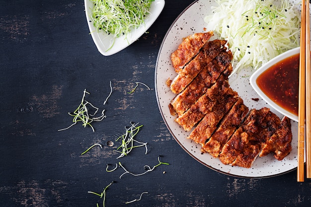 Gefrituurde varkenskotelet met kool en tonkatsu-saus.