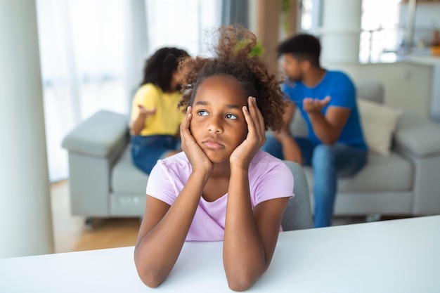 Gefrustreerd meisje voelt zich depressief terwijl boze ouders vechten thuis bezorgd overstuur kleine dochter gekwetst door vaders en moeders gaan uit elkaar of scheiden