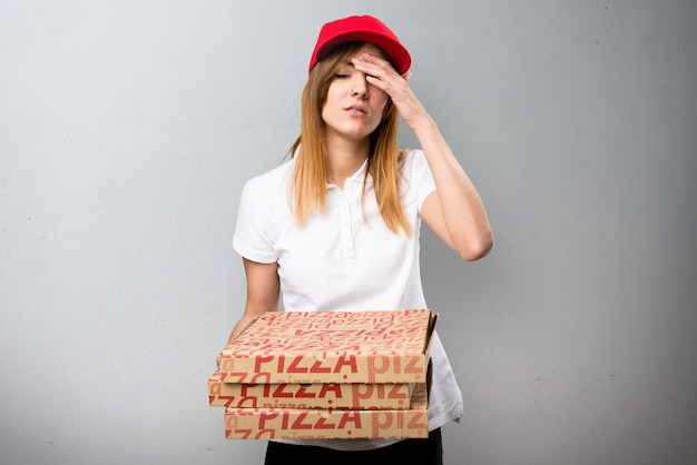 Gefrustreerde pizzakoeriersvrouw op geweven achtergrond