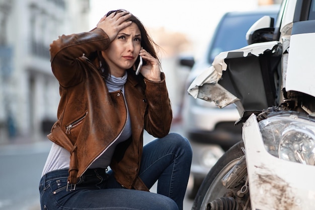 Gefrustreerde vrouw die om hulp vraagt na het auto-ongeluk