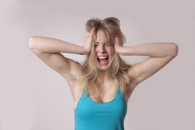Gefrustreerde vrouw die tegen de muur staat thuis.