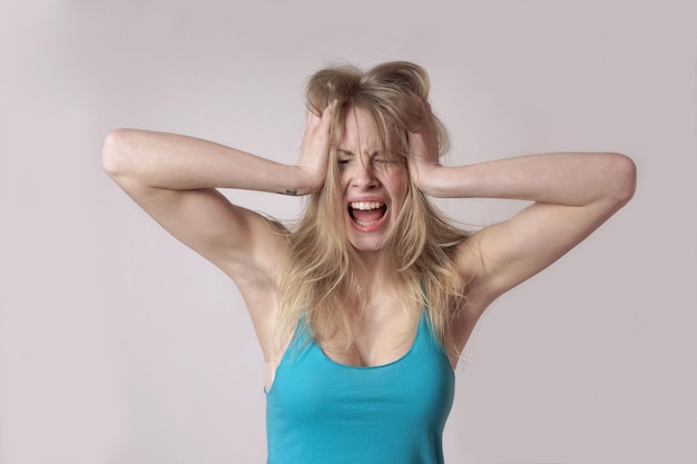 Foto gefrustreerde vrouw die tegen de muur staat thuis.