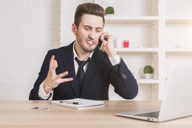 Gefrustreerde zakenman aan de telefoon