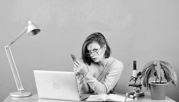 Gegevens en informatie Zakelijke communicatie scheikundige bioloog met Microscoop op tafel vrouw werk in kantoor op laptop secretaresse gebruik mobiele telefoon op werkplek digitale wetenschap zakenvrouw