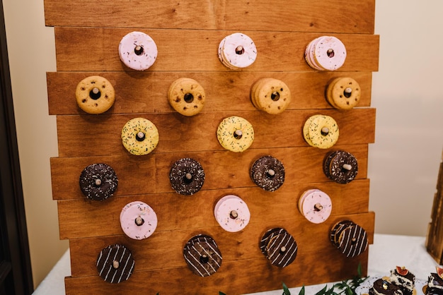 Geglazuurde mini donuts op houten achtergrond Party food concept met kopie ruimte Geassorteerde donuts met chocolade frosted roze glazuur en hagelslag donuts Banner