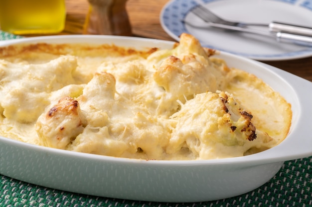 Gegratineerde bloemkool met Parmezaanse kaas in een witte plaat.