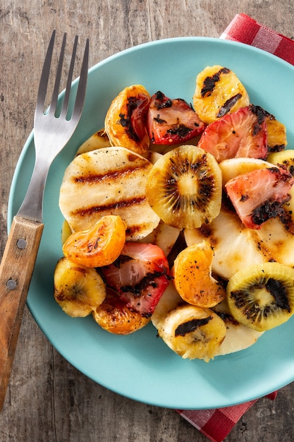 Gegrild fruit op een blauw bord en een witte houten tafel