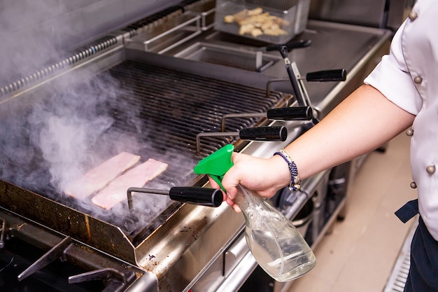 Gegrild spek door chef-kok in keukenrestaurant. Heerlijke snelle keuken