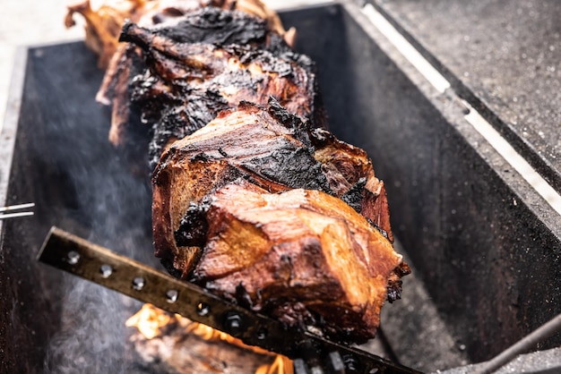 Gegrild varkensvlees tot zwart verkoold boven een metalen grill barbecueën