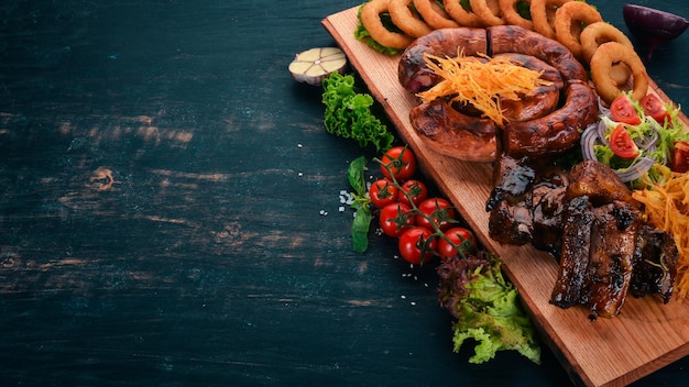 Gegrild vlees op het bord Worstribben en verse groenten Op een houten tafel Bovenaanzicht Kopieer de ruimte