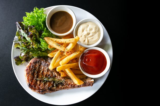 Gegrild vlees, Porkchops steak met pepersaus en salade.