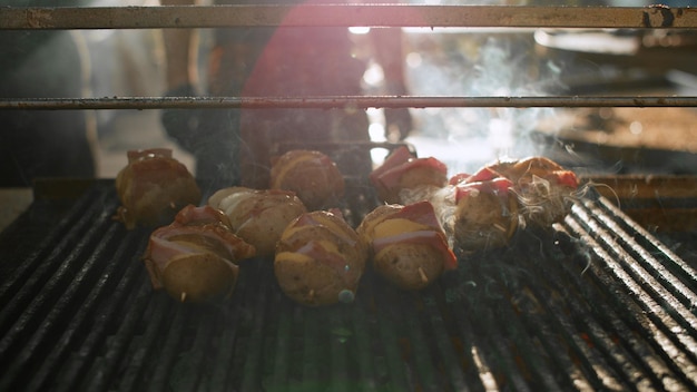 Foto gegrilde aardappel met ham buiten bereiden chef-kok man koken op achtertuin