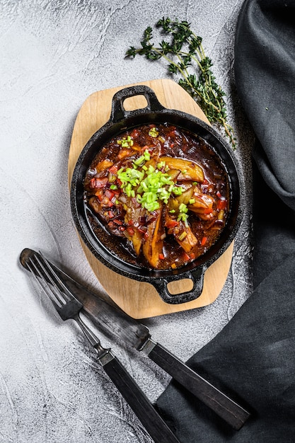 Gegrilde aubergine in een gietijzeren koekenpan. Grijze achtergrond. Bovenaanzicht