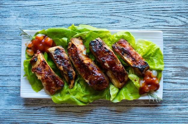 Gegrilde barbecue varkensribbetjes met groenten op een houten tafel