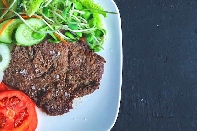 Gegrilde biefstuk en gezonde salades op tafel