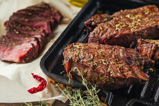 Gegrilde biefstuk op koekenpan, bovenaanzicht. Gebakken stukjes vlees close-up