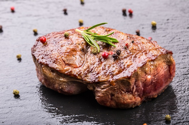 Gegrilde biefstuk op leisteen bord met zout peper en rozemarijn.