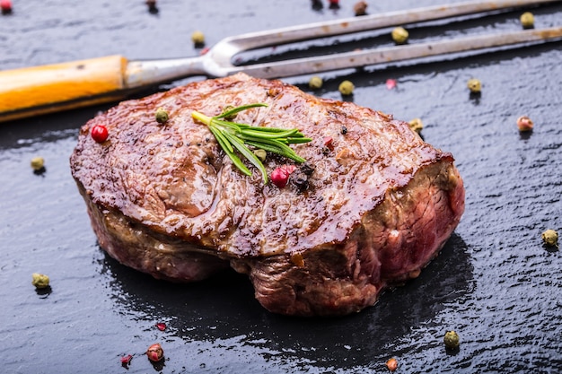 Gegrilde biefstuk op leisteen bord met zout peper en rozemarijn.