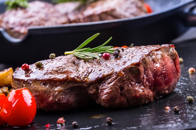 Gegrilde biefstukken met champignons, tomaten en kruiden.