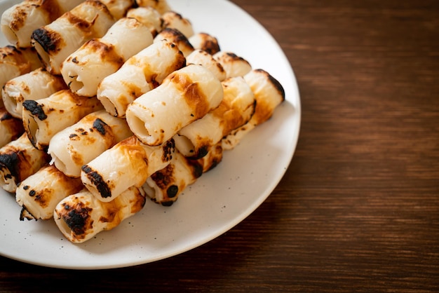 Gegrilde buisvormige vispastacake of buisinktvisspies op bord