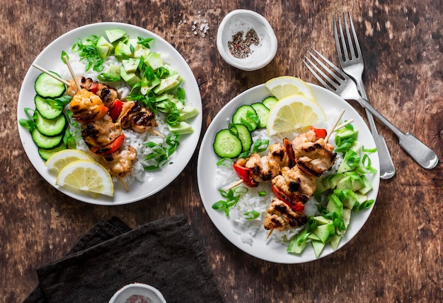 Gegrilde chili honing limoen kipspiesjes met rijst en avocado salsa op houten achtergrond