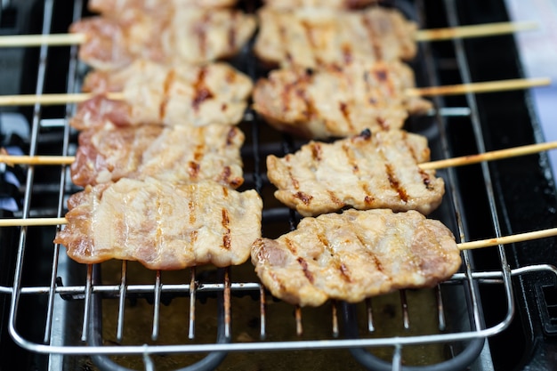 Gegrilde doorstoken varkensvlees op het fornuis. Thais eten.