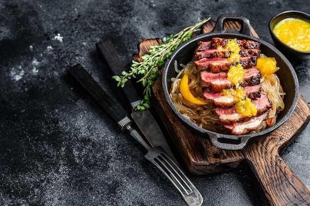 Gegrilde eendenborstfilet steak met noedels en mandarijnensaus.