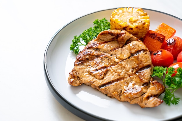 gegrilde en gegrilde varkenshaas met maïs, wortel en tomaten