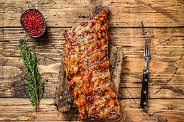 Gegrilde en gerookte spareribs van varkensvlees. Houten tafel. Bovenaanzicht.