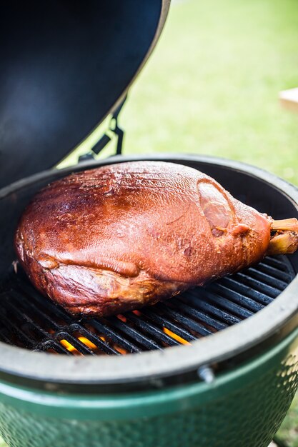 Gegrilde en gerookte varkensdij op professionele grill Praagse ham grillen in de tuin