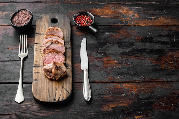 Gegrilde ganzenborstset, op houten serveerplank, op oude donkere houten tafel