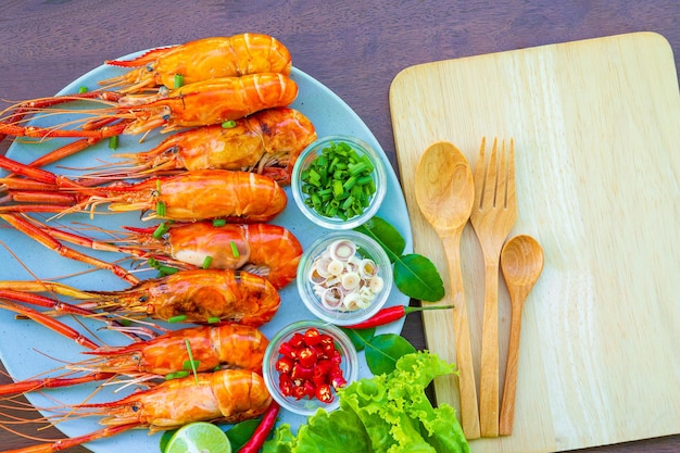 Gegrilde garnalen en zeevruchtensaus is erg lekker op een witte plaat op een houten ondergrond